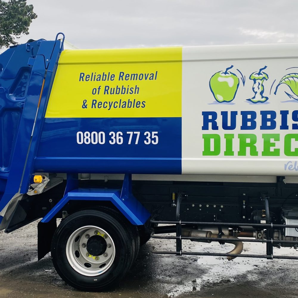 Blue and white rubbish removal truck with a yellow sign that says 'Reliable Removal of Rubbish & Recyclables' and the phone number 0800 36 77 35.